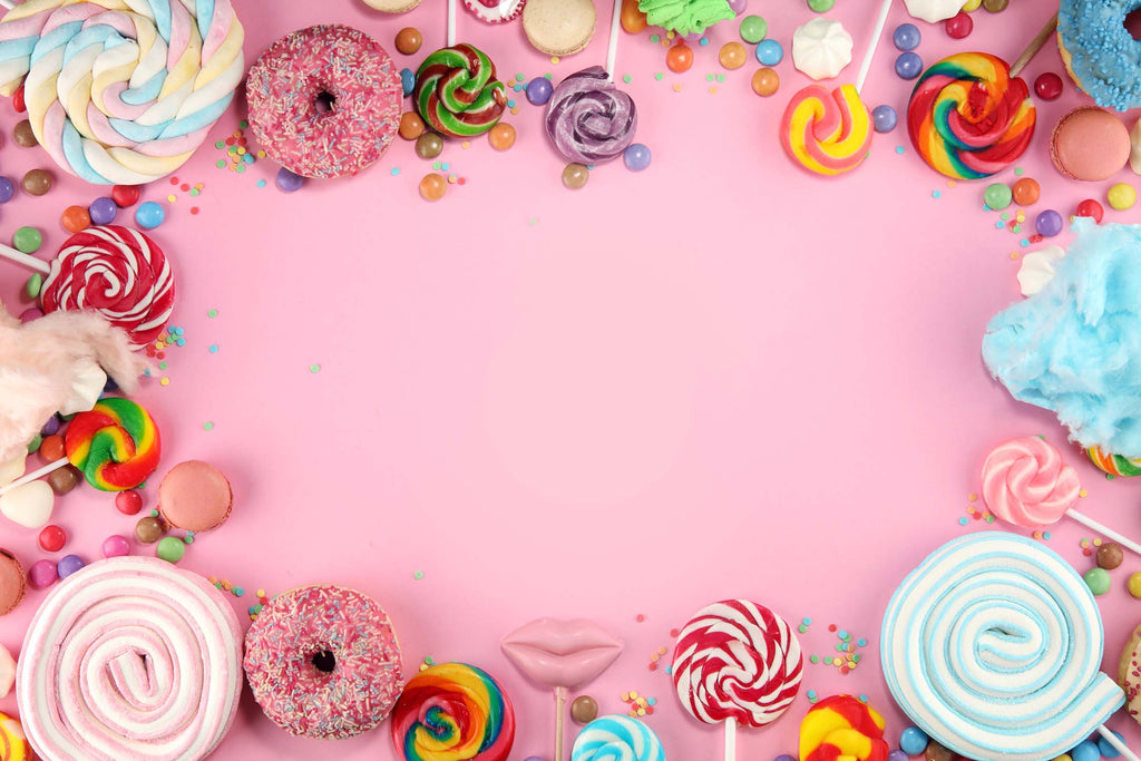 Pinker Hintergrund mit verschiedenen Süßigkeiten an den Rändern